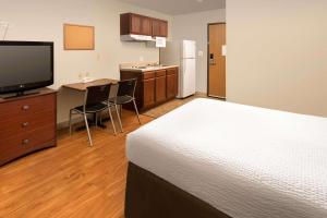 um quarto de hotel com uma cama, uma secretária e uma televisão em WoodSpring Suites Killeen em Killeen