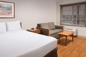a bedroom with a bed and a chair and a window at WoodSpring Suites Killeen in Killeen