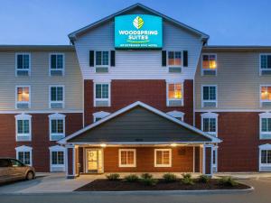 a hotel with a sign on the front of a building at WoodSpring Suites Richmond West I-64 in Richmond