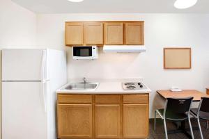 a small kitchen with a sink and a refrigerator at WoodSpring Suites Austin North I-35 in Austin