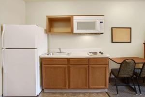 a kitchen with a white refrigerator and a sink at WoodSpring Suites Richmond West I-64 in Richmond