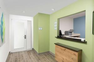 an empty room with green walls and a mirror at WoodSpring Suites Austin North I-35 in Austin