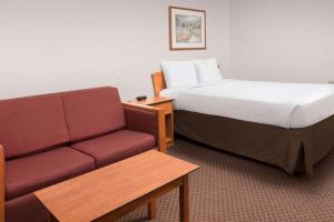 a hotel room with a bed and a couch at WoodSpring Suites San Antonio North Live Oak I-35 in San Antonio