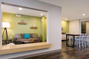 a living room and dining room with a couch and a table at Woodspring Suites Houston IAH Airport in Humble
