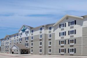 a large white building with black windows at WoodSpring Suites Houston Westchase in Houston