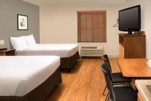 A bed or beds in a room at WoodSpring Suites Odessa