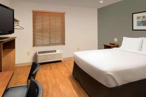 A bed or beds in a room at WoodSpring Suites Odessa