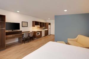 une chambre d'hôtel avec une cuisine et un salon dans l'établissement WoodSpring Suites Houston Northwest, à Houston