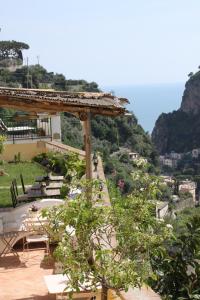 un cenador con mesas y sillas en una colina en Villa Torre Dello Ziro, en Ravello