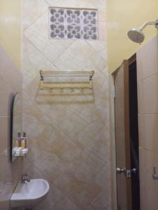a bathroom with a sink and a toilet and a shower at Losmen Setia Kawan in Yogyakarta