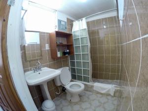 y baño con aseo, lavabo y ducha. en Chila's Accommodations en Caye Caulker