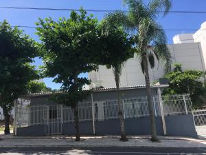 巴拉奈里奧－坎布里烏的住宿－CASA PRAIA A 600m DO MAR，两棵棕榈树,在一座建筑前