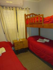 1 dormitorio con 2 literas con sábanas rojas en Casa de Vacaciones ADELITA en 