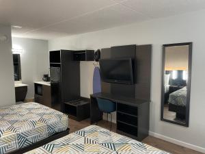 a hotel room with a bed and a desk with a television at Studio 6 Vicksburg, MS- Downtown in Vicksburg +16 photos
