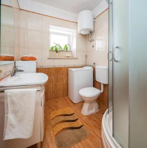 ein Badezimmer mit einem weißen WC und einem Waschbecken in der Unterkunft Holiday home Gita - peacefull in Sutivan