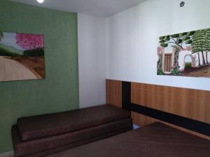 een wachtkamer met een bank en schilderijen aan de muur bij 504-AP-com bebidas liberadas no parque aquatico e internet banda larga in Caldas Novas