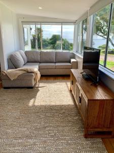 un soggiorno con divano e TV di Salty Dog a Emu Bay