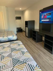 a hotel room with two beds and a flat screen tv at Motel 6 San Diego Airport/Harbor in San Diego