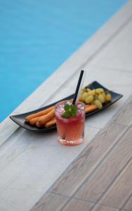 a drink sitting on a table next to a plate of food at Ionian Diamond Villas in Mikros Gialos