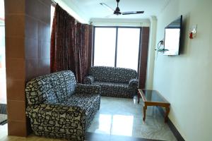 a living room with a couch and a chair at Hotel Dream World Boarding & Lodging in Sivaganga