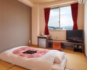 大洲的住宿－橋本旅籠飯店，一间卧室配有一张大床和电视