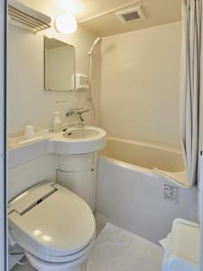 uma casa de banho branca com um WC e um lavatório em Hatago Hashimoto em Ozu