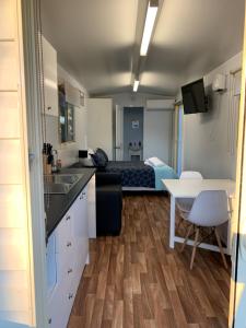 a kitchen with a table and a room with a bed at Wine Country Tourist Park Hunter Valley in Nulkaba