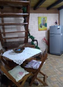 a kitchen with a table and chairs and a refrigerator at Cabaña Maracuya in Jardín América
