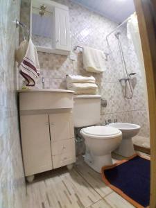 a bathroom with a toilet and a sink and a shower at Cabaña Maracuya in Jardín América