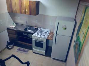 a small kitchen with a stove and a refrigerator at Cabaña Maracuya in Jardín América