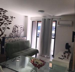 un soggiorno con divano e tavolo in vetro di NA BEIRA MAR DE PAJUCARA- EDIF NEO- APARTAMENTO QUARTO E SALA - POSSUI VARANDA- VISTA LATERAL DO MAR-RUA JULIO PLECH FILHO 60 ESQUINA COM AVENIDA DOUTOR ANTONIO GOUVEIA - CONSUMO ELETRICO É PAGO No CKECK-OUT - 1 KWH É 1,35 REIAS a Maceió