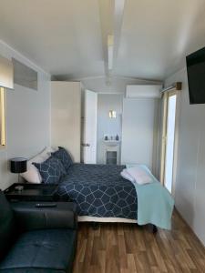 - une chambre avec un lit et un canapé dans l'établissement Wine Country Tourist Park Hunter Valley, à Nulkaba