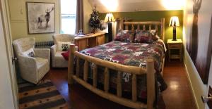 a bedroom with a wooden bed and a chair at Holiday Lodge Bed and Breakfast in Banff