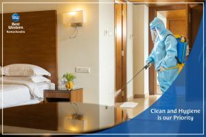 a person in a room with a vacuum at Best Western Ramachandra in Visakhapatnam