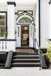 una entrada a una casa blanca con escaleras en St Marks Randwick, en Sídney