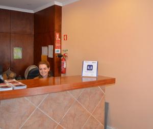 uma mulher está sentada num balcão numa clínica em Residencial Mariazinha by Petit Hotels no Funchal