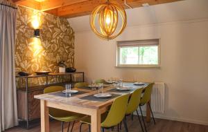 a dining room with a wooden table and green chairs at Tsjep in De Bult