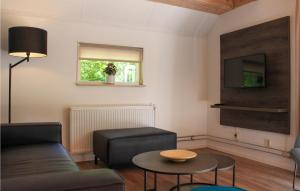 een woonkamer met een bank, een tafel en een tv bij Noflik in De Bult