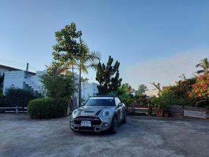 a small car parked in a parking lot at Scenic Riverside Resort in Kamphaeng Phet