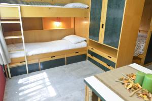 メッツァーナにあるResidence Bucaneveの小さなお部屋で、二段ベッドとテーブルが備わります。