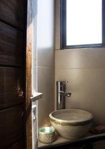 a bathroom with a toilet with a bowl on a shelf at La casa de la paz in Potrerillos