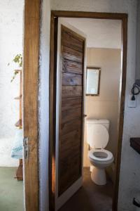 a bathroom with a toilet and a wooden door at La casa de la paz in Potrerillos