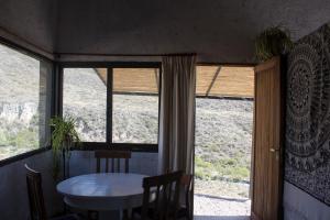 a table and chairs in a room with a window at La casa de la paz in Potrerillos