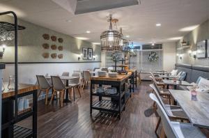a dining room with tables and chairs in a restaurant at Strandplevier Suites in De Koog