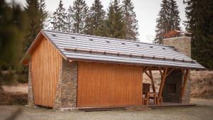 a small cabin with a metal roof on top at Penzion Horska Kvilda in Horská Kvilda