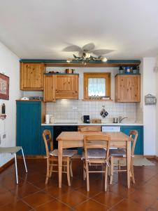 una cocina con armarios de madera, mesa y sillas en Appartamento il Sole, en Ponte di Legno