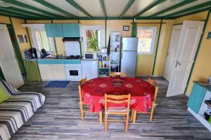 eine Küche mit einem roten Tisch und Stühlen im Zimmer in der Unterkunft Maison à Saint-leu, vue exceptionnelle sur la baie et l'Océan à 2 minutes des plages in Saint-Leu