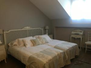 1 dormitorio con 1 cama con sábanas blancas y ventana en Albus Albi, en Colmenar del Arroyo