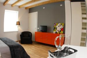 チヴィダーレ・デル・フリウーリにあるCasa Galanteのベッドルーム(ベッド1台、ドレッサー内のテレビ付)