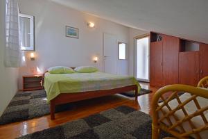 a bedroom with a bed with a green bedspread on it at Apartments Dinka Miličić in Hvar